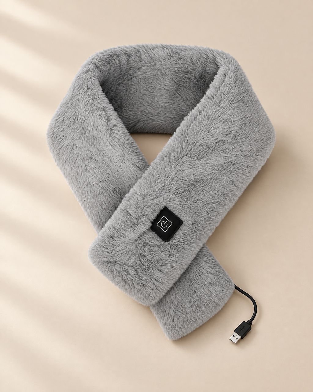 Grey Cinderly USB heated scarf folded on a soft sand studio background